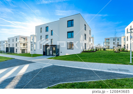 Modern residential complex with green areas and pathways on sunny day 120843685