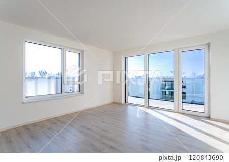Empty living room with laminate floor and french windows offering city view Empty living room with laminate floor and french windows offering city view 120843690
