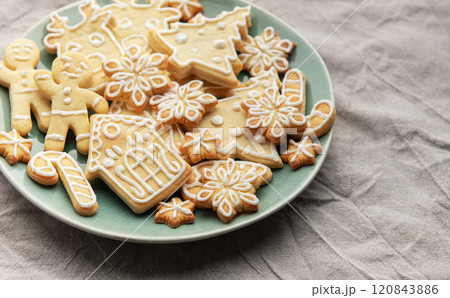 Christmas cookies with white icing forming various shapes lying on a plate 120843886