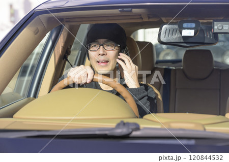 スマホで通話しながら運転する男性（イメージ） 120844532
