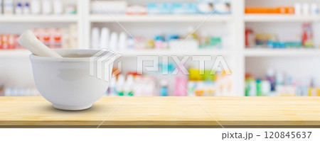 Mortar and pestle on pharmacy counter top with blur medicine shelves in drugstore background Mortar and pestle on pharmacy counter top with blur medicine shelves in drugstore background 120845637