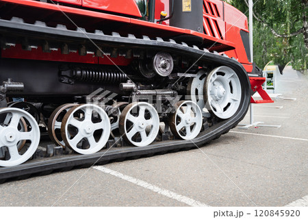 Close-up of red tracked vehicle's wheels and suspension system. 120845920