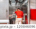 Butcher touching head entering cold storage room in slaughterhouse 120846096