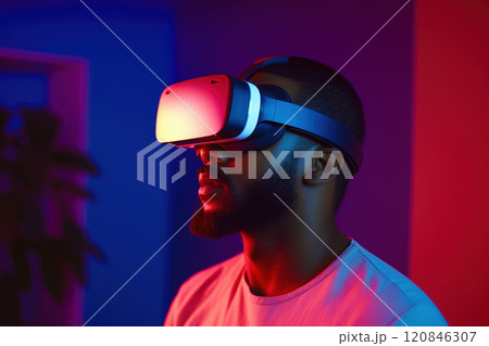 Portrait of African American man wearing VR headset at home in neon light. Portrait of African American man wearing VR headset at home in neon light. 120846307