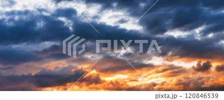Background with a beautiful orange sunset on a blue cloudy sky with clouds at sunrise. Panorama of sky 120846539
