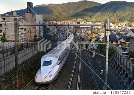 【京都】夕日があたる街中を一気に走り抜ける新幹線 【京都】夕日があたる街中を一気に走り抜ける新幹線 120847228