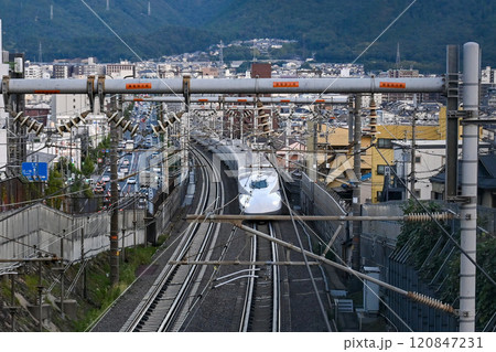 【京都】夕日があたる街中を一気に走り抜ける新幹線 120847231
