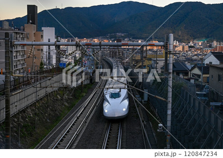 【京都】夕日があたる街中を一気に走り抜ける新幹線 【京都】夕日があたる街中を一気に走り抜ける新幹線 120847234