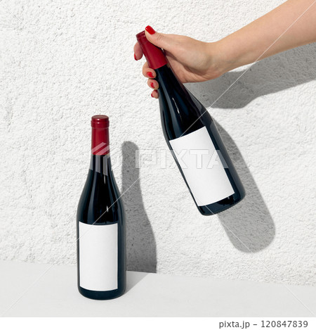 Hand holding a red wine bottle mockup with a white label, perfect for branding ideas and realistic presentations. Negative space for your ad, brand name. Hand holding a red wine bottle mockup with a white label, perfect for branding ideas and realistic presentations. Negative space for your ad, brand name. 120847839