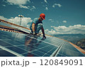 Technician Installing Solar Panels on Rooftop 120849091