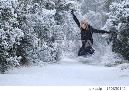 Young woman jumping in snow outdoor. Young woman jumping in snow outdoor. 120850142