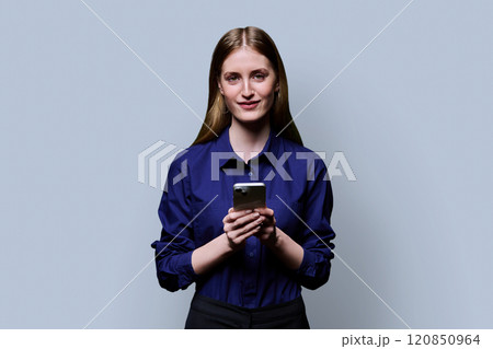 Young beautiful woman using smartphone on grey studio background 120850964