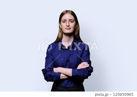 Beautiful young girl with crossed arms looking at camera on white background 120850965