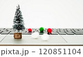Miniature Christmas tree and colorful pom poms on a laptop during the holiday season 120851104