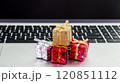 Small decorative gift boxes placed on a laptop keyboard during the holiday season 120851112