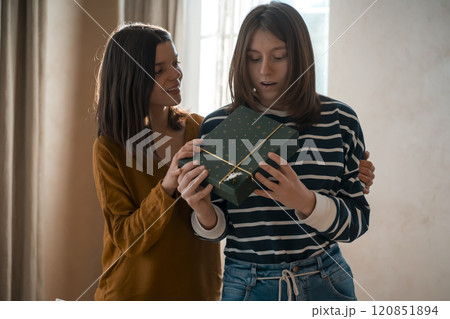 Two happy girls celebrate holiday, making nice gifts. 120851894