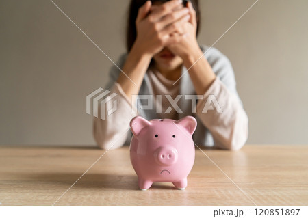 Sad girl with a piggy bank at home. Sad girl with a piggy bank at home. 120851897