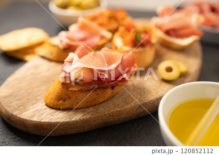 Tasty bruschettas with cheese and Prosciutto di Parma ham served with wine on gray background 120852112