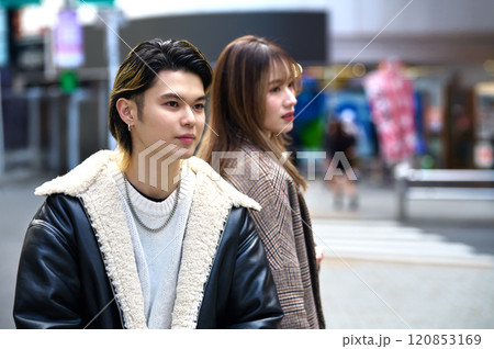 渋谷の街をバックスマホを操作する若いカップル 120853169