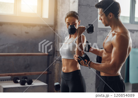 A Couple Working Out Together in a Modern Gym, Engaging in Physical Fitness Activities 120854089
