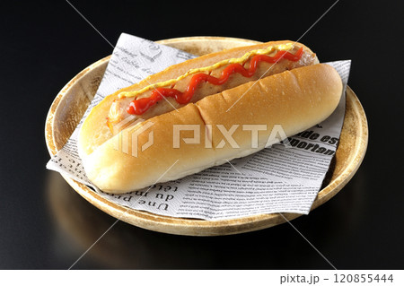 ケチャップとマスタードがかかったホットドックを黒背景で撮影 120855444