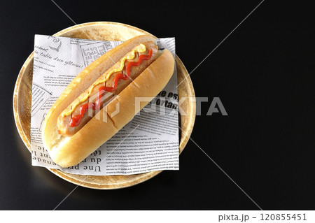 ケチャップとマスタードがかかったホットドックを黒背景で撮影 120855451
