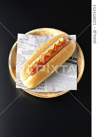 ケチャップとマスタードがかかったホットドックを黒背景で撮影 120855453