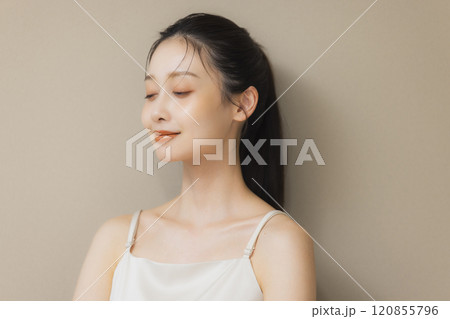 顔に手を当てて微笑む女性 120855796