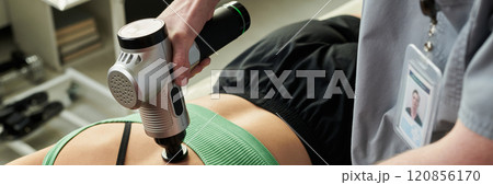 Performing Percussion Therapy on Person's Back with Device 120856170