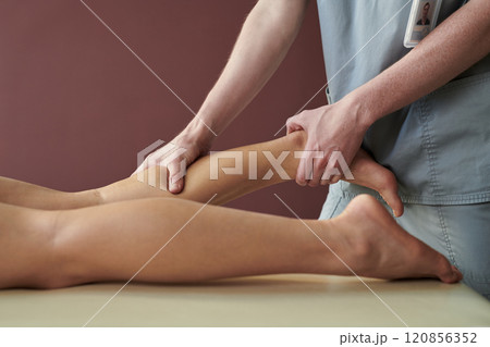 Conducting a Massage on Relaxed Client's Leg Conducting a Massage on Relaxed Client's Leg 120856352