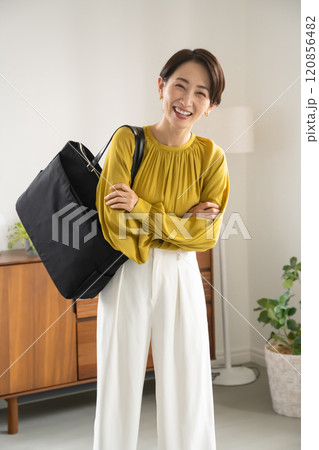 屋内でショルダーバッグを持って立つ女性 120856482