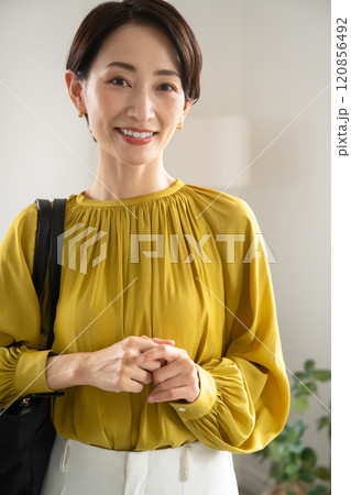 屋内でショルダーバッグを持って立つ女性 屋内でショルダーバッグを持って立つ女性 120856492