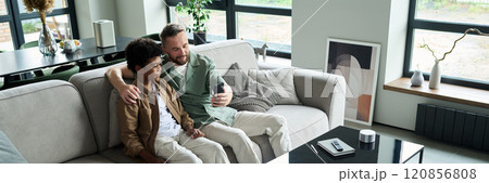 Bonding Moment Between Father and Son Sitting on Sofa Bonding Moment Between Father and Son Sitting on Sofa 120856808