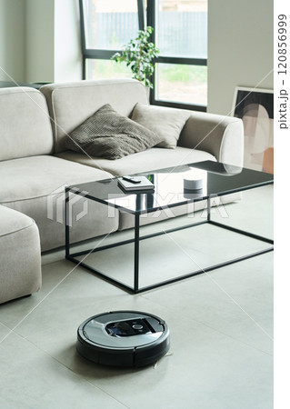 Robotic Vacuum Cleaner Navigating Modern Living Room 120856999