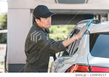 洗車するつなぎを着た整備士の男性 120858217