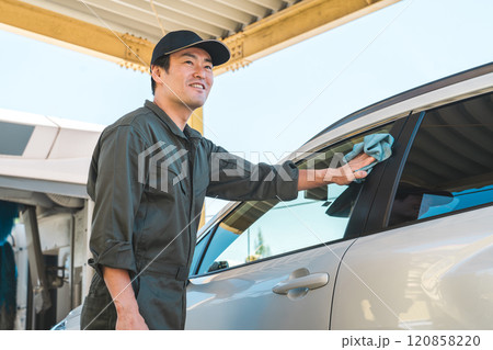洗車するつなぎを着た整備士の男性 120858220