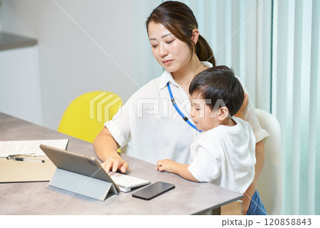 子供を抱えて仕事をする女性 子供を抱えて仕事をする女性 120858843