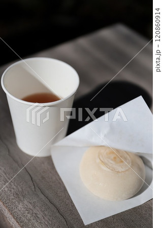 屋外ベンチに置いた食べ歩きの焼き餅とお茶 120860914