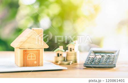 close up house's model on banking account book with calculator, House placed on coins on table for planning of home loan mortgage refinance or retention interest rates 120861401