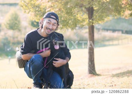 ペットの大型犬に舐められる飼い主の男性 秋 ペットの大型犬に舐められる飼い主の男性 秋 120862288