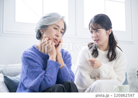 高齢の母親の相談を聞く娘と迷ったり困る母親　娘に注意や怒られる悩むなどのネガティブなイメージ	 120862597