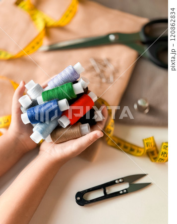 Colorful threads and sewing tools on tailors workspace 120862834