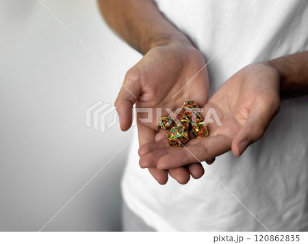 Person holding colorful polyhedral dice for role-playing games 120862835