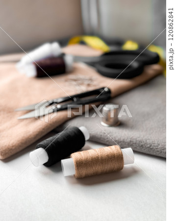 Sewing essentials. Threads, scissors, and thimble in soft light Sewing essentials. Threads, scissors, and thimble in soft light 120862841