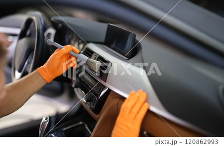 Hands in gloves with a dust brush, detailing 120862993