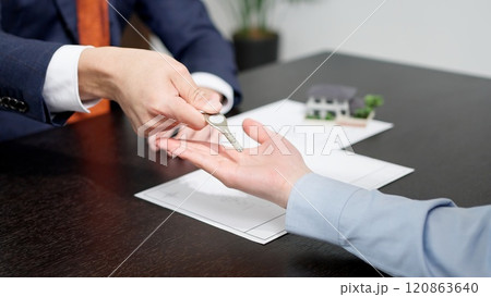 家の鍵を渡すビジネスマンの手元 家の鍵を渡すビジネスマンの手元 120863640