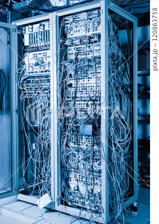 server room rack with tangled network cables creating messy unti 120863758
