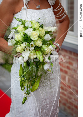 An Elegant Bridal Bouquet complemented by a Stunning Dress at a Picturesque Outdoor Wedding An Elegant Bridal Bouquet complemented by a Stunning Dress at a Picturesque Outdoor Wedding 120863890