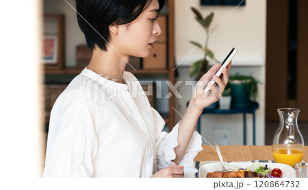 食事中にスマホを見る女性 食事中にスマホを見る女性 120864732