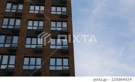 brown brick high rise building view from bottom to top against light blue sky, architectural background with modern residential building brown brick high rise building view from bottom to top against light blue sky, architectural background with modern residential building 120864924
